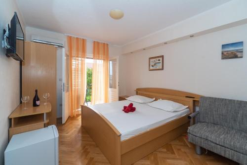 a hotel room with a bed and a chair at Villa Tomislav in Baška Voda