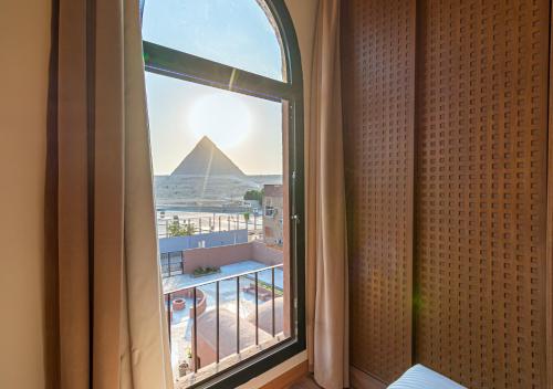 a room with a window with a view of the pyramid at Le Pacha BoutiQue Hotel in Cairo
