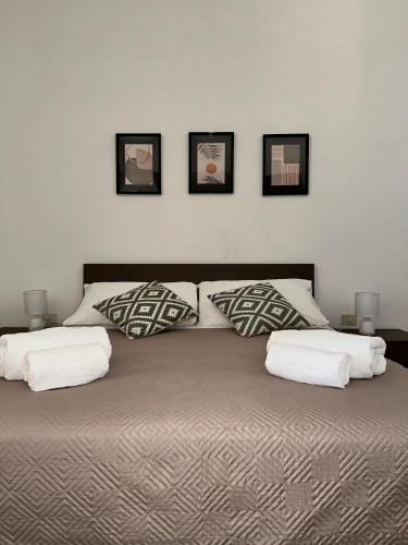 a bedroom with a large bed with three pillows at Casa Moi in Brindisi