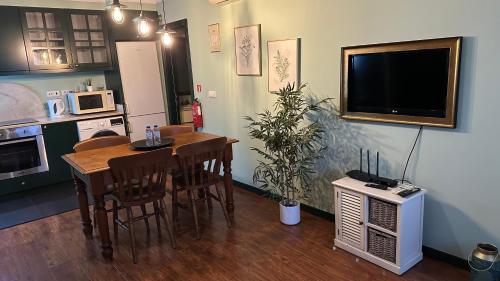 a kitchen with a dining room table and a television at Studio by Casa da Quinta in Funchal