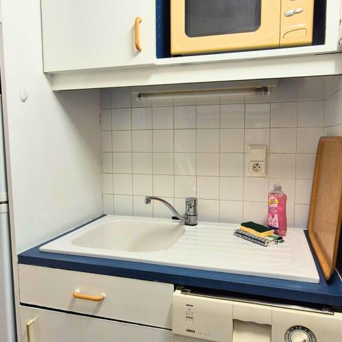 un comptoir de cuisine avec un évier et un micro-ondes dans l'établissement Studio proche plage et cœur de ville, à La Grande Motte