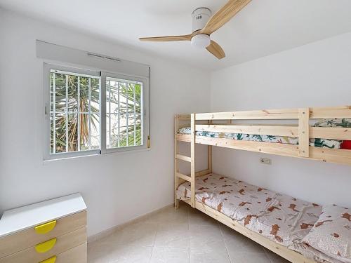 a bedroom with bunk beds and a ceiling fan at El Mirador de Peñiscola in Peñíscola