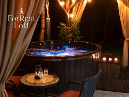a hot tub on a patio with a table and chairs at ForRest Loft in Poręby Kupieńskie