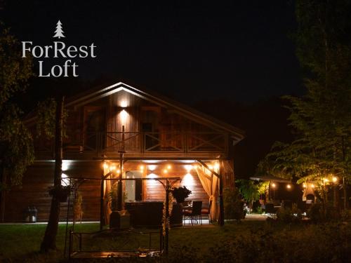 a cabin lit up at night with a forest lot at ForRest Loft in Poręby Kupieńskie