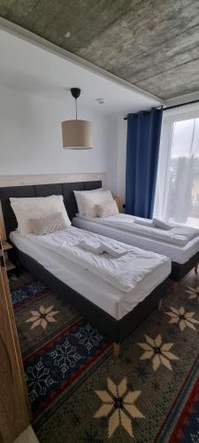 two beds sitting in a room with a window at USTROŃ RESIDENCE by VillaOlimpijska2 in Ustroń