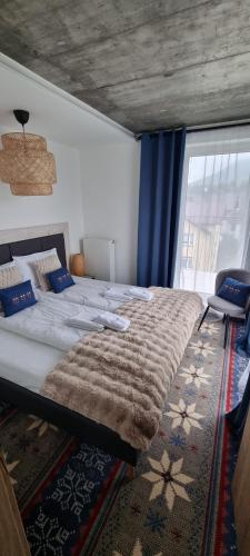 a bedroom with a large bed and a window at USTROŃ RESIDENCE by VillaOlimpijska2 in Ustroń