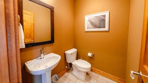 a bathroom with a white toilet and a sink at S-Turns - 3-Bedroom, 3-Bathroom Suite at REAL Watersports in Waves