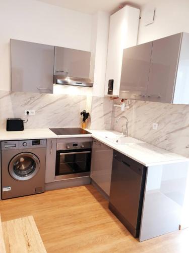 une cuisine avec un évier et une machine à laver dans l'établissement Sadi Carnot - 1A, à Millau