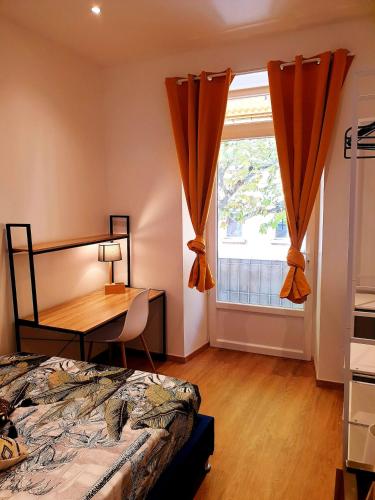 une chambre avec un lit, un bureau et une fenêtre dans l'établissement Sadi Carnot - 1A, à Millau