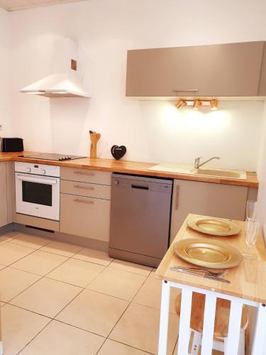 - une cuisine avec un comptoir, un évier et une cuisinière dans l'établissement Sadi Carnot - 3A, à Millau