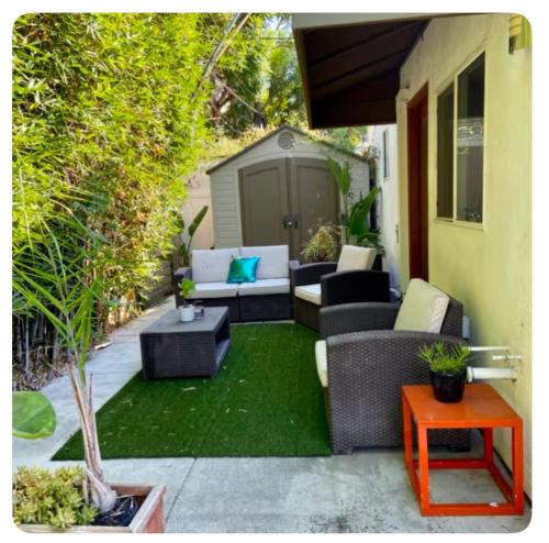 a patio with couches and tables on a yard at PRIVATE modern studio Guesthouse in Los Angeles