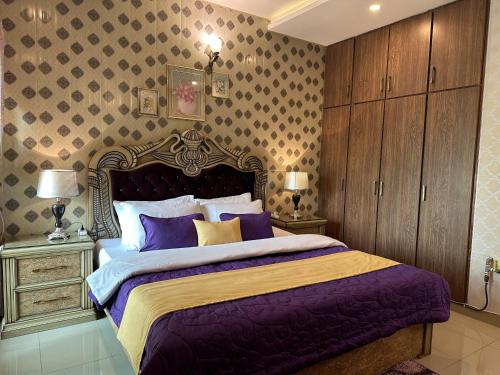 a bedroom with a large bed with purple sheets at Stylish Luxe 2 BedroomLK Condo Close to GIGA Mall in Islamabad