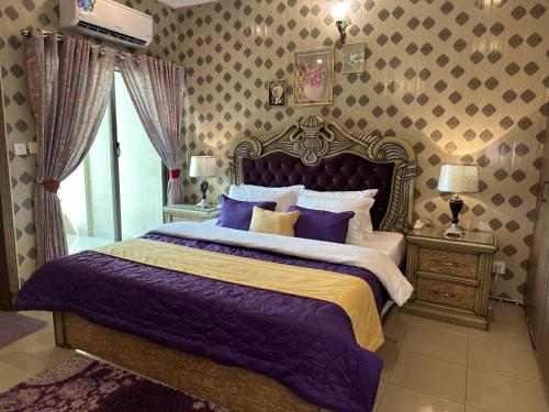 a bedroom with a large bed with purple sheets at Stylish Luxe 2 BedroomLK Condo Close to GIGA Mall in Islamabad