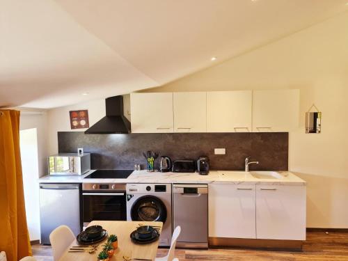 une cuisine avec des armoires blanches et un four à plaques de cuisson dans l'établissement Rep - 4A, à Millau