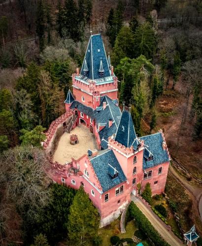 an aerial view of a large pink house with a blue roof at Zámecká Stodola - Červený Hrádek u Sedlčan in Sedlčany
