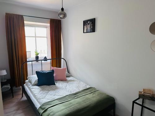 a bedroom with a bed with pillows on it at Kobal Apart in Bolesławiec