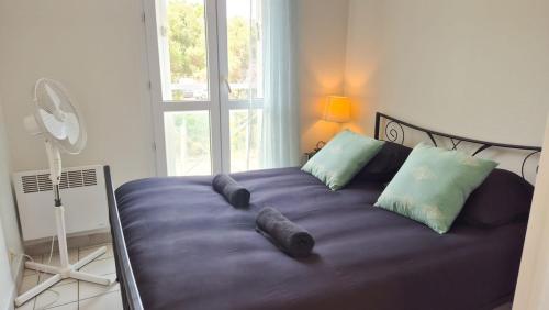 un grand lit violet avec des oreillers et une fenêtre dans l'établissement Appartement 2P, balcon, parking proche mer, à Nice