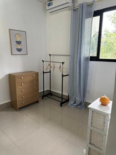 a living room with a dresser and a window at Galini home in Motsouémbé