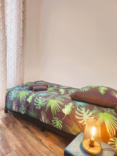 - un lit avec une couette colorée et une table dans l'établissement Mitrons - 1B, à Saint-Affrique