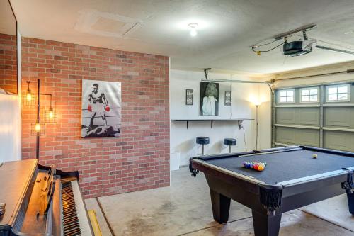 a room with a pool table and a brick wall at Private Pool and Patio Pet-Friendly Bakersfield Gem in Bakersfield