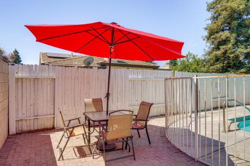 a table and chairs with a red umbrella on a patio at Private Pool and Patio Pet-Friendly Bakersfield Gem in Bakersfield