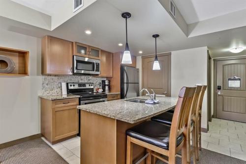 a kitchen with a island with a counter top at Luxury Two Bedroom Condo near Canmore Banff in Dead Man's Flats
