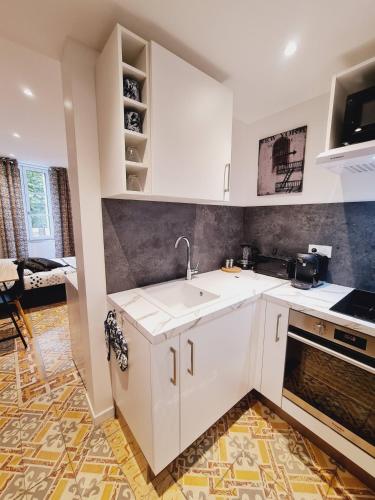 une cuisine blanche avec un évier et une cuisinière dans l'établissement Rep - 2B, à Millau