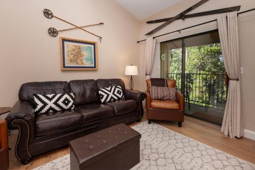 sala de estar con sofá de cuero y silla en Pool, Hot Tubs, Sauna, Hiking from the Property, On Free Bus Route, en Winter Park