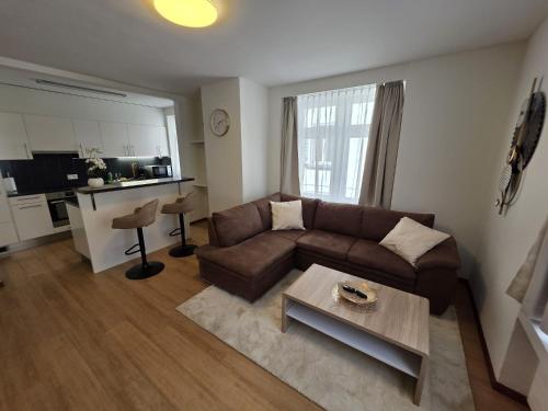 a living room with a brown couch and a table at Hotel Surselva in Chur
