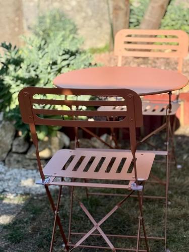 a picnic table and a chair in a yard at Le petit nid douillet à 5mn du Futuroscope in Jaunay-Marigny