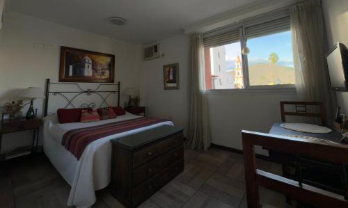 1 dormitorio con 1 cama con tocador y ventana en En el Corazón de Salta, en Salta