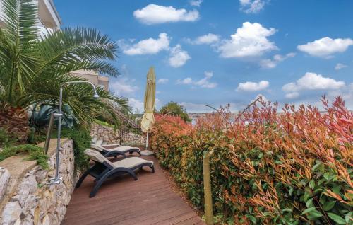 a wooden deck with a bench and an umbrella at MERTIK Apartment in Omišalj