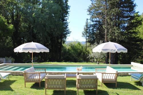 - un groupe de chaises longues et de parasols à côté de la piscine dans l'établissement Quiet Provencal bastide with pool close Lourmarin, à Lauris