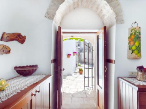 Un arco que conduce a una cocina con una puerta abierta. en Panoramic Terrace, en Alberobello