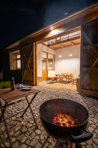 an outdoor grill with a table and a picnic table at Stodola 63 in Pacov
