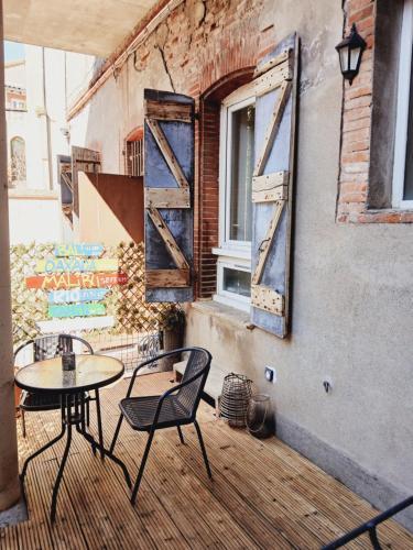 un patio avec une table, des chaises et une fenêtre dans l'établissement chez Nino le surfer Globe- trotteur, à Toulouse