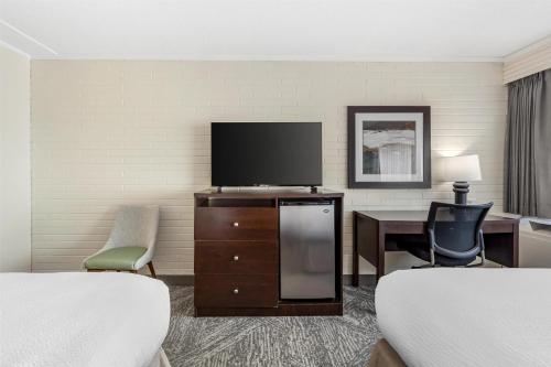 a hotel room with two beds and a flat screen tv at Best Western Cedar Park Inn in Edmonton