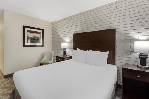 a bedroom with a large bed and a brick wall at Best Western Cedar Park Inn in Edmonton