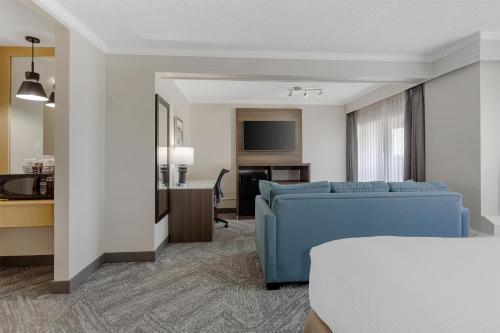 a hotel room with a blue couch and a desk at Best Western Cedar Park Inn in Edmonton