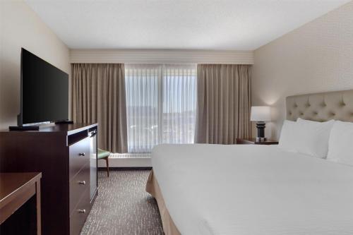 a hotel room with a large bed and a television at Best Western Cedar Park Inn in Edmonton
