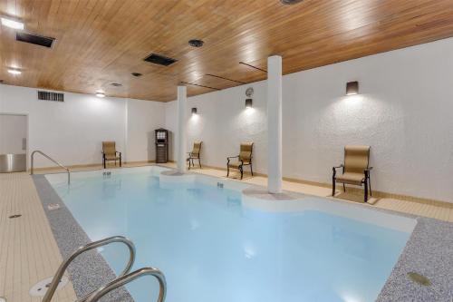 a large swimming pool with chairs and a wooden ceiling at Best Western Cedar Park Inn in Edmonton