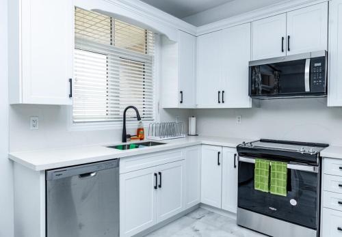 a white kitchen with white cabinets and a sink at Vacation Home in Vaughan in Vaughan