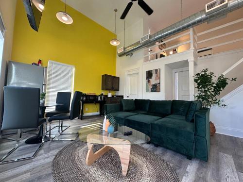 a living room with a green couch and a table at 30-A Inn & Suites in Santa Rosa Beach