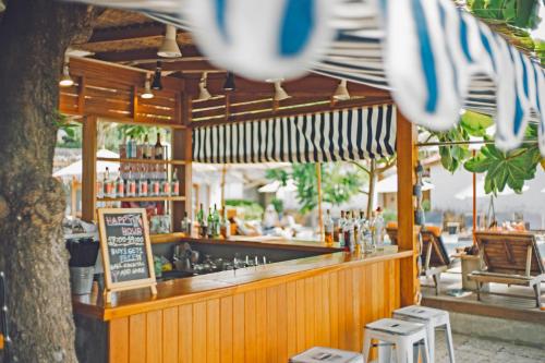a bar with umbrellas and a counter with drinks at Escape Beach Resort - SHA Extra Plus Certified in Mae Nam
