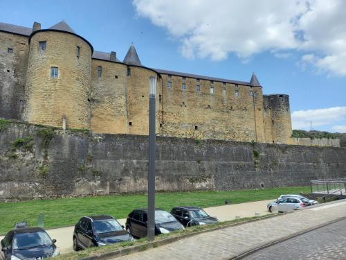 a group of cars parked in front of a large castle at La locomotive by La BB12087 in Nouvion-sur-Meuse