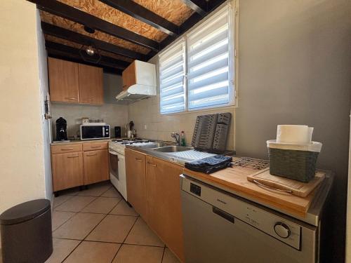 une cuisine avec un évier et une cuisinière four supérieur dans l'établissement GuestHouse avec terrasse & jacuzzi- La Teste de Buch, à La Teste-de-Buch