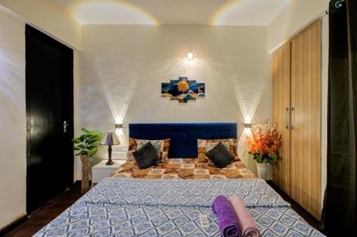a bedroom with a large bed with a blue comforter at City view stay by Royal Rooms in Noida