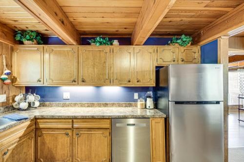 a kitchen with wooden cabinets and a stainless steel refrigerator at Canal Across Street Family Cabin in Breezy Point! in Pequot Lakes