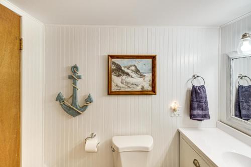 a bathroom with a toilet and a picture and a sink at Canal Across Street Family Cabin in Breezy Point! in Pequot Lakes