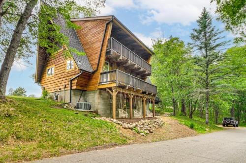 a large wooden house on a hill with trees at Canal Across Street Family Cabin in Breezy Point! in Pequot Lakes